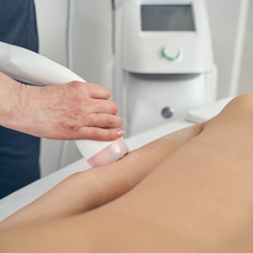 Beauty treatment of young woman in modern clinic with hand probe